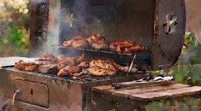 Pollo ahumándose en el asador de tambo